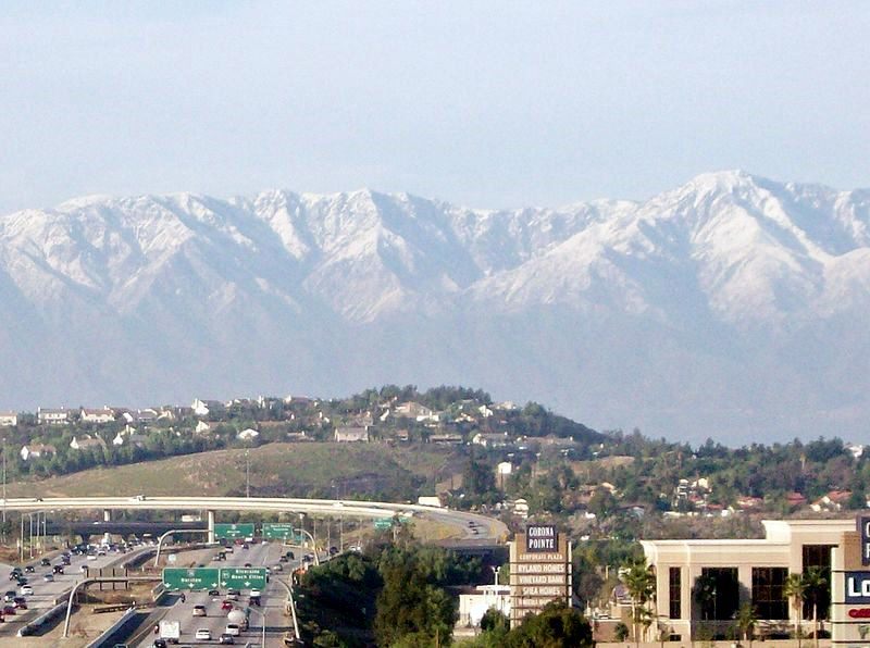 Corona, California — the 91 and 15 freeway interchange with the snow-capped San Gabriel Mountains in the background