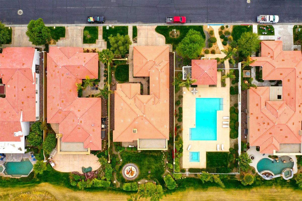 Aerial view of Palm Desert neighborhood with terracotta rooftops, pools, and desert landscape